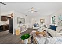 Bright living room with hardwood floors, ceiling fan, neutral color palette, and access to the kitchen at 124 Oak Ridge Ave, Edgewater, FL 32132