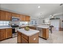 Well-lit kitchen featuring wood cabinets, stainless steel appliances, and a central island at 13826 Mirror Lake Dr, Orlando, FL 32828
