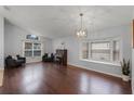 Spacious living room with hardwood floors, an elegant light fixture, and large windows at 13826 Mirror Lake Dr, Orlando, FL 32828
