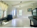 Comfortable living area featuring tile floors, bright windows, stylish curtains, and a grand piano at 16611 Toccoa Row, Winter Garden, FL 34787