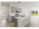 Open kitchen featuring a center island, stainless appliances, and sliding doors to the backyard at 192 Duckweed Ave, Fruitland Park, FL 34731