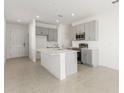 Open kitchen with gray cabinets, stainless appliances, center island, and tile flooring at 192 Duckweed Ave, Fruitland Park, FL 34731