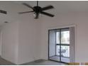Bright living room with sliding glass door to balcony and a ceiling fan at 2002 Cascades Blvd # 201, Kissimmee, FL 34741