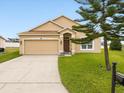 Beautiful single-story home featuring a well-maintained lawn, two car garage, and inviting front entrance at 204 Cotswold Cir, Davenport, FL 33837