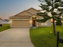 Attractive one-story home, showcasing lush lawn, a two-car garage, and a welcoming entrance at 204 Cotswold Cir, Davenport, FL 33837