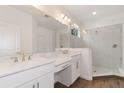 Modern bathroom with double sinks, a glass shower, and white marble-style tiling at 2261 Sirena Ln, Mount Dora, FL 32757