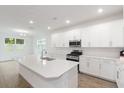 Bright, open kitchen features white cabinets, an island, and stainless steel appliances at 2261 Sirena Ln, Mount Dora, FL 32757