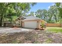 Side view of a one-story home featuring a two-car garage, and well manicured landscaping at 30926 County Road 435, Sorrento, FL 32776