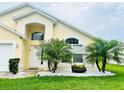 This attractive home features a well-manicured lawn with bright white decorative rocks and vibrant palm trees at 318 Langham Dr, Davenport, FL 33897