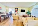 Bright living room with a large window, a dining table with seating for eight, and laminate wood flooring at 318 Langham Dr, Davenport, FL 33897
