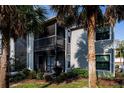 View of the condo featuring a screened-in patio with outdoor furniture and lush landscaping at 3748 Idlebrook Cir # 202, Casselberry, FL 32707
