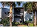 Condominium with a screened-in patio featuring outdoor furniture surrounded by lush landscaping and palm trees at 3748 Idlebrook Cir # 202, Casselberry, FL 32707