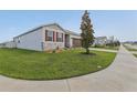 Well-maintained single-Gathering home showing the side yard and landscaping at 394 Quayside Ave, Mascotte, FL 34753