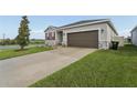 Attractive one-story home with an attached two-car garage and a driveway at 394 Quayside Ave, Mascotte, FL 34753