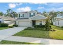 Charming two-story home featuring a well-maintained lawn, two-car garage, and welcoming gray-tone facade at 3941 Willowbrook Dr, Edgewater, FL 32141
