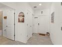 Bright hallway featuring neutral tile, white walls, and decorative artwork, leading to various rooms at 3941 Willowbrook Dr, Edgewater, FL 32141