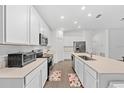 Modern kitchen with a large island, stainless steel appliances, and white cabinetry offers ample counter space at 3977 Willowbrook Dr, Edgewater, FL 32141