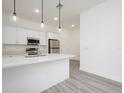 The kitchen features stainless steel appliances, white cabinets, and an island with quartz countertops at 404 Famagusta Dr, Davenport, FL 33896