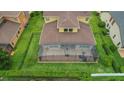 Aerial view of the home featuring a large screened lanai and well-maintained yard enclosed by a black fence at 4265 Foxhound Dr, Clermont, FL 34711