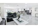 Open-concept living room and kitchen with marble floors and sleek, modern design offers style and functionality at 516 Petes Ln, Davenport, FL 33837