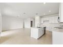 Open-concept living space with a kitchen island and neutral-toned tile flooring at 797 Lemon Ave, Fruitland Park, FL 34731
