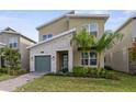 Charming two-story home with a stone accent wall, a green garage door, and a well-manicured lawn at 9227 Sommerset Hills Dr, Davenport, FL 33896