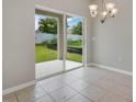 Open dining area features tile flooring, sliding glass doors, and modern light fixture at 928 Pearlwood Loop, Eagle Lake, FL 33839