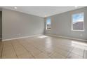 Spacious living room features tile flooring, recessed lighting, and natural light from two large windows at 928 Pearlwood Loop, Eagle Lake, FL 33839