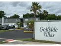 Community sign for Golfside Villas with building exteriors and mature palm trees at 1000 S Semoran Blvd # 608, Winter Park, FL 32792
