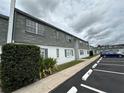 Side exterior view with gray shingles, white paint, parking spaces, and green landscaping at 1000 S Semoran Blvd # 608, Winter Park, FL 32792
