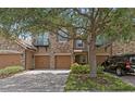 Attractive townhome exterior featuring stone accents, a private balcony, multi-car garage, and lovely tree at 10308 Belfry Cir, Orlando, FL 32832
