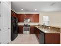 Features a kitchen with tile flooring, granite countertops, and stainless steel appliances at 15208 Avenue Of The Arbors, Winter Garden, FL 34787