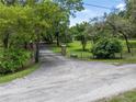 Long, private driveway leading to a gated entrance surrounded by lush greenery at 1550 Kevin Ln, Deland, FL 32724