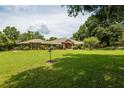 Expansive front yard leading to a charming brick home with a red front door at 1550 Kevin Ln, Deland, FL 32724
