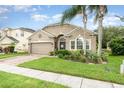 Inviting one-story home with lush landscaping, mature palm trees, and a well-maintained lawn at 15606 Montesino Dr, Orlando, FL 32828