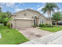 Well-kept one-story home with a brick-paved driveway, lush lawn, and tropical landscaping at 15606 Montesino Dr, Orlando, FL 32828