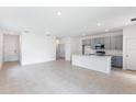Open-concept living room with tile flooring, gray kitchen, and ample space for entertaining at 196 Duckweed Ave, Fruitland Park, FL 34731