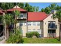 Condo exterior features a red roof, neutral siding, and balconies amidst lush landscaping at 236 Afton Sq # 309, Altamonte Springs, FL 32714