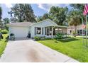 Exterior view of a single-story home with a garage and a well-kept lawn, showcasing curb appeal at 2597 Cr 426F, Lake Panasoffkee, FL 33538