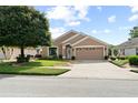 Inviting single-story home showcases a well-maintained lawn, attractive landscaping, and a two-car garage at 30108 Pga Dr, Sorrento, FL 32776