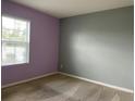 Bedroom features neutral carpet, gray accent wall, a window bringing in natural light and a calming ambiance at 316 Tanglewood Dr, Davenport, FL 33896