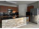Modern kitchen with stainless steel appliances, granite countertops, stone backsplash and island with breakfast bar at 316 Tanglewood Dr, Davenport, FL 33896