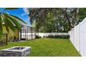 Spacious backyard featuring a fire pit, a white fence, and greenery, perfect for outdoor enjoyment and relaxation at 328 E Minnehaha Ave, Clermont, FL 34711