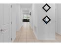 Bright hallway with tiled flooring, decorative mirrors, and a view into the living area at 4223 Little Owl Ln, Kissimmee, FL 34746