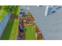 Aerial view of a private backyard with a wooden deck, lush lawn, and mature landscaping at 4545 Southfield Ave, Orlando, FL 32812