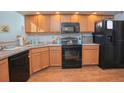 Kitchen features wood cabinets, black appliances, and granite countertops at 4545 Southfield Ave, Orlando, FL 32812