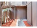 An up-close entrance to the building with light brown wooden siding and mulched garden beds at 5301 Burning Tree Dr # F, Orlando, FL 32811