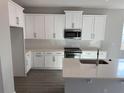 Modern kitchen featuring quartz countertops, white cabinets and island, and stainless appliances at 551 Pothos St, Apopka, FL 32703