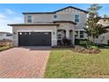 Charming two-story home featuring a stone entryway, brick driveway, well-kept lawn, and attached two-car garage at 5550 Sabal Dr, St Cloud, FL 34771