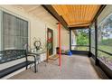 View of a screened porch featuring a wood ceiling, door, and seating to enjoy the outdoors at 618 Acapulca Way, Altamonte Springs, FL 32714